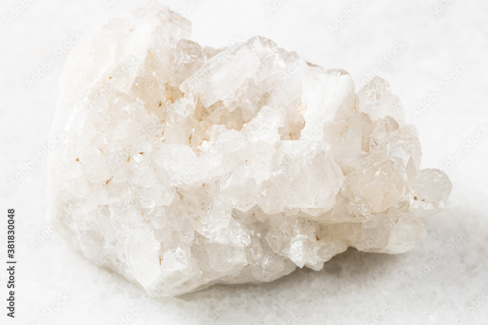 closeup of sample of natural mineral from geological collection - unpolished druse of colorless Rock crystals (rock-crystal) on white marble background from China closeup of sample of natural mineral from geological collection - unpolished druse of colorless Rock crystals (rock-crystal) on white marble background from China
