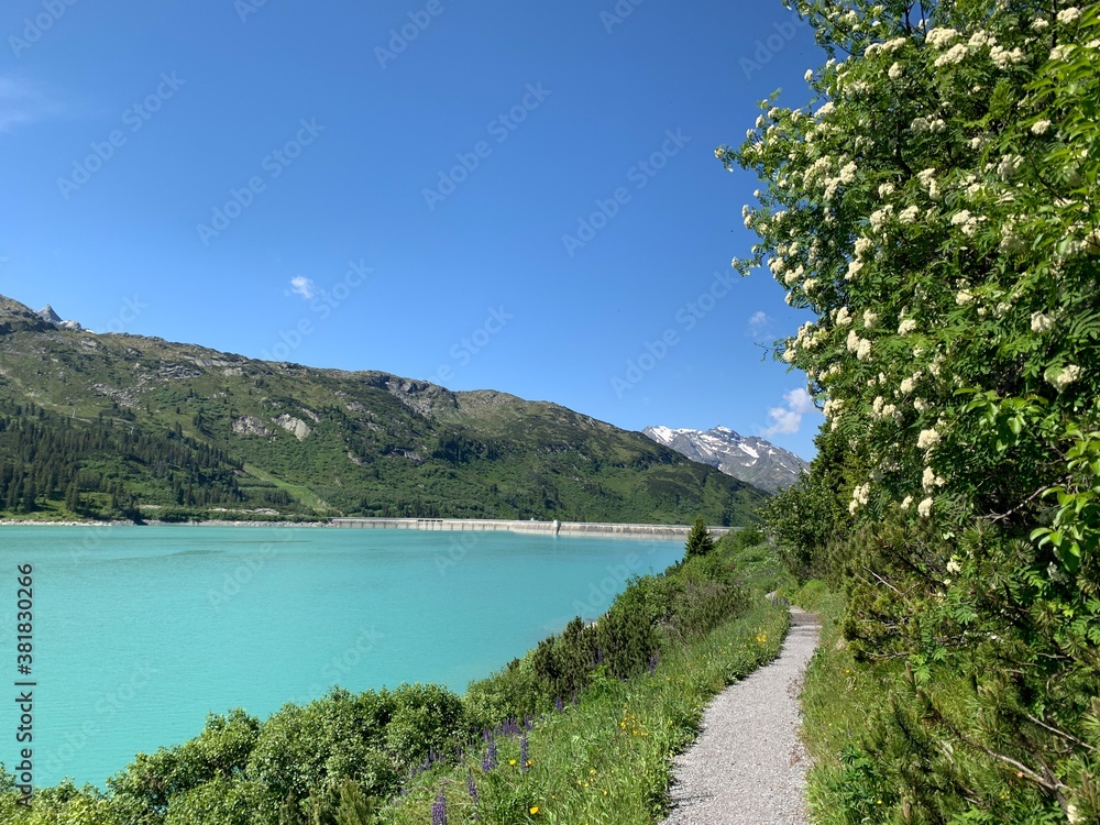 Stausee Kops in Tirol mit Wanderweg an einem sonnigen Sommertag bei strahlend blauem Himmel