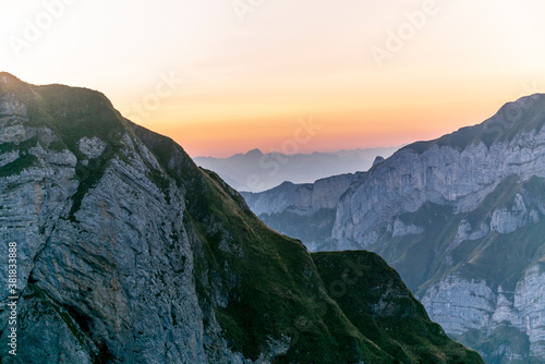 Fototapeta Naklejka Na Ścianę i Meble -  Colorful sunrise on the steep ridge of the majestic  Schaefler peak in the Alpstein mountain range Appenzell, Switzerland with the fog covering the Seealpsee valley