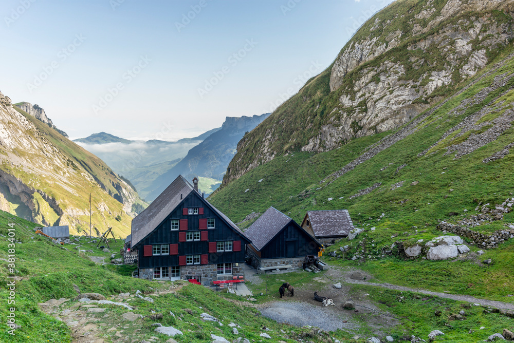 Typical Appenzell wooden cabins in the Swiss alps in a fall misty morning