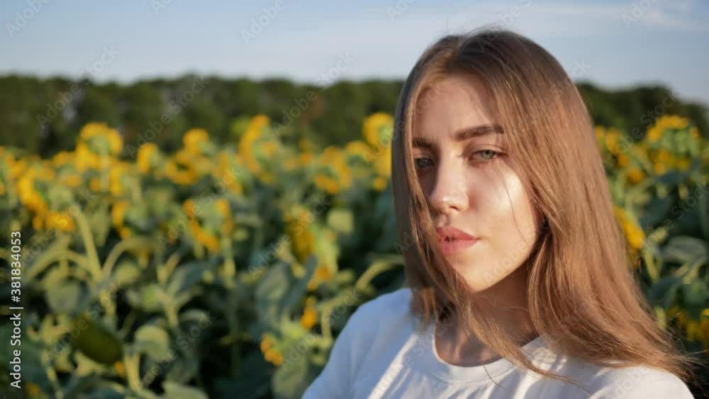 Close-up portrait of young woman agronomist on background of sunflower field Close-up portrait of young woman agronomist on background of sunflower field