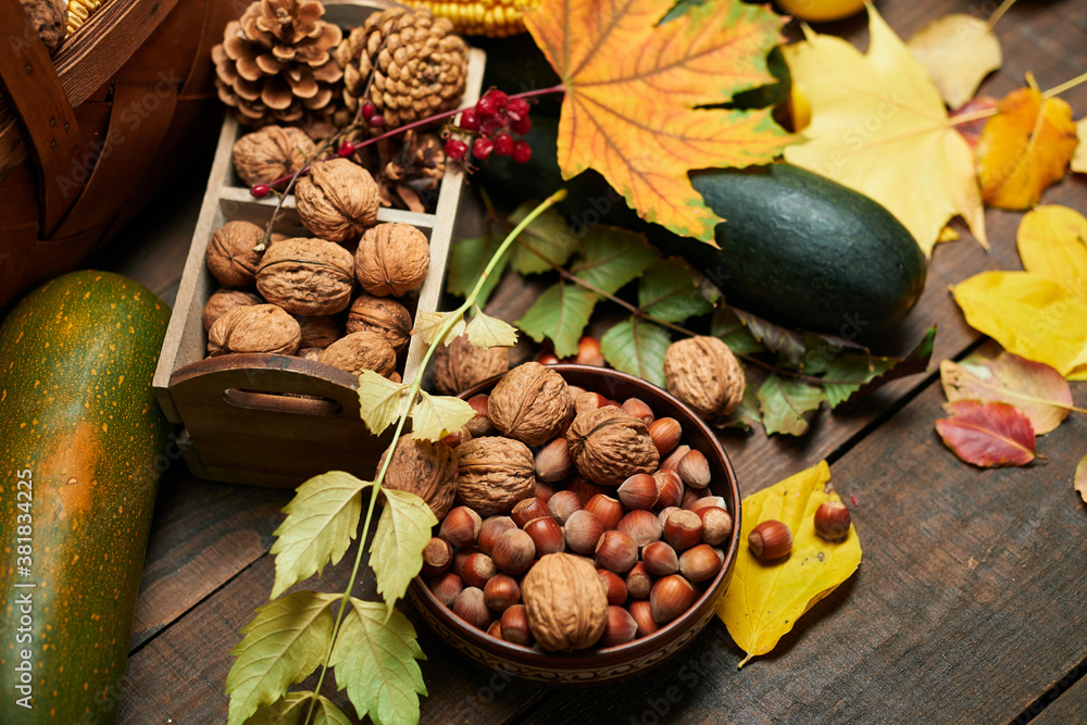 autumn still life in rustic style as a background - leaves, vegetables and fruits, nuts and other natural food ingredients on wooden boards