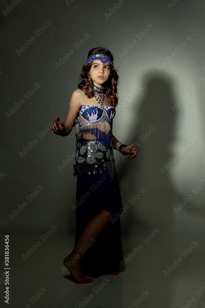 Beautiful teen girl in a blue suit oriental dance
