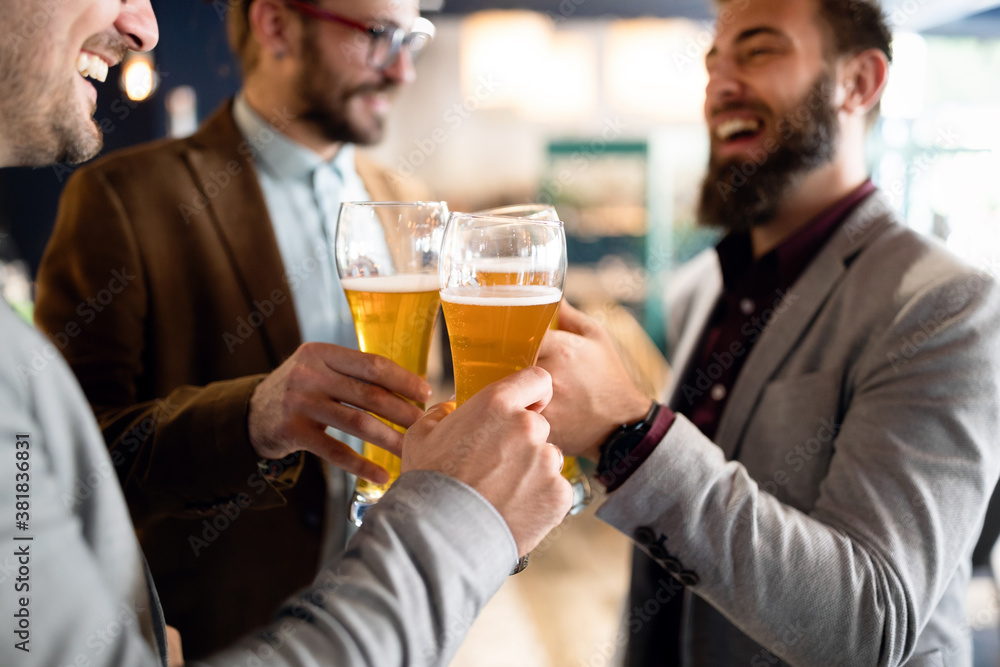 Happy young business men talking and drinking beer in a pub Happy young business men talking and drinking beer in a pub