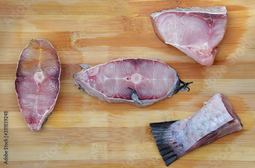 Uncooked slices or cut pieces of Rohu Fish (roho labeo) on a wooden board photo