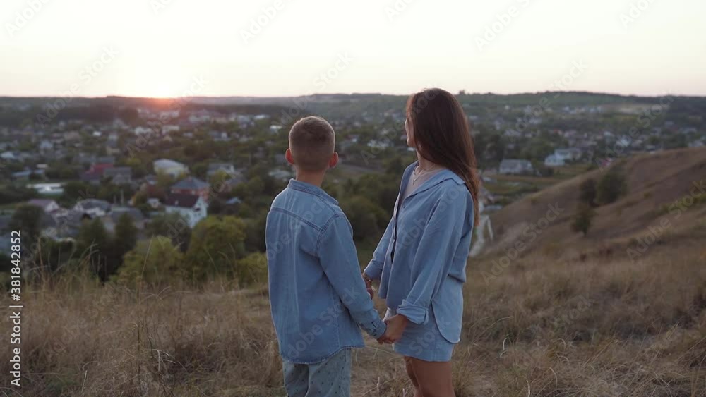 Mom and son walk the hills at sunset Mom and son walk the hills at sunset