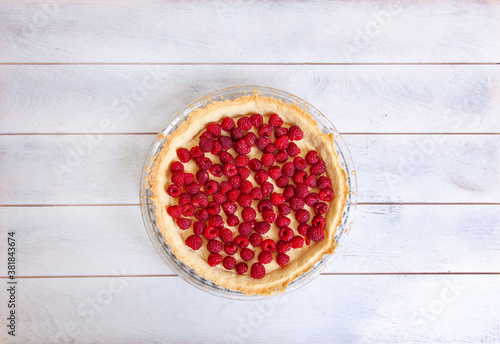 Preparation of shortbread pie with raspberries on white wooden background, top view