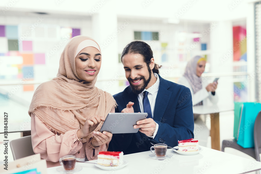 Obraz premium Arabian Couple Sitting in Cafe after Shopping.