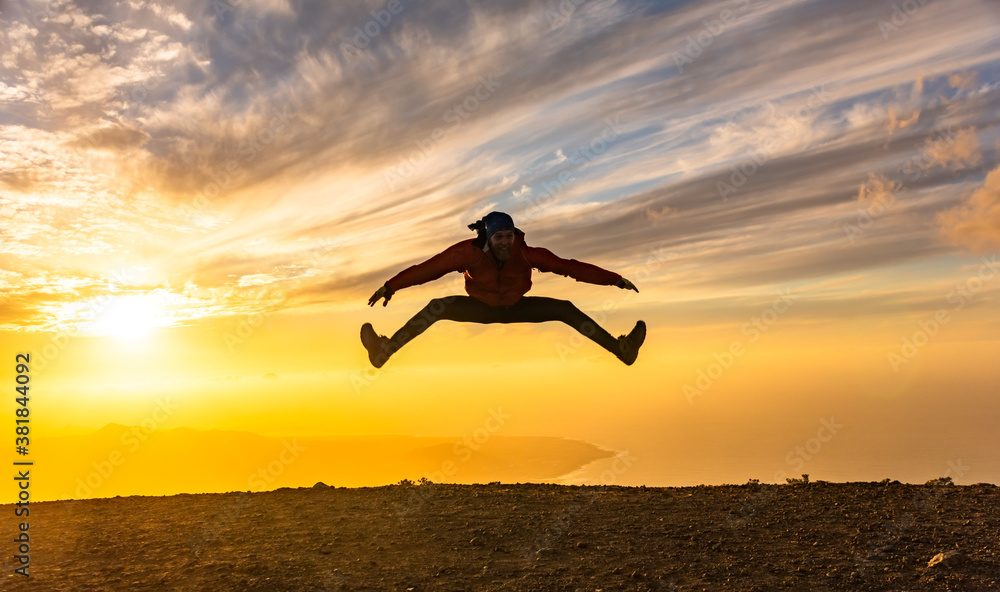 Happy man jumping for joy at sunset. Success, winner, happiness, ttavel concept. - obrazy, fototapety, plakaty 