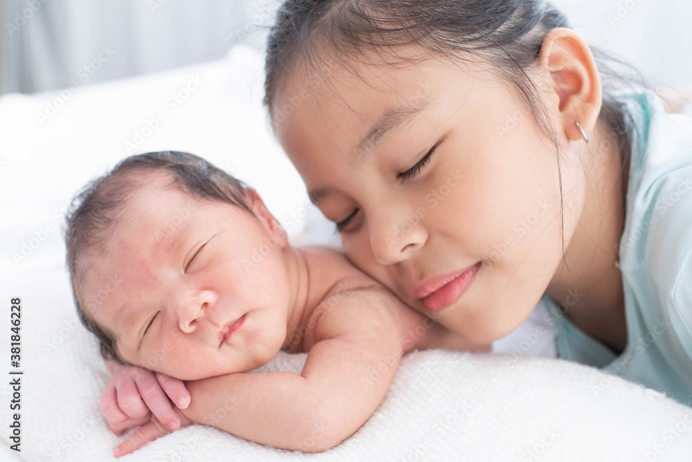 little sister hugging her newborn brother. toddler kid meeting new sibling. love, trust and tenderness. cute girl and new born baby boy relax in a white bedroom. family with children at home. little sister hugging her newborn brother. toddler kid meeting new sibling. love, trust and tenderness. cute girl and new born baby boy relax in a white bedroom. family with children at home.