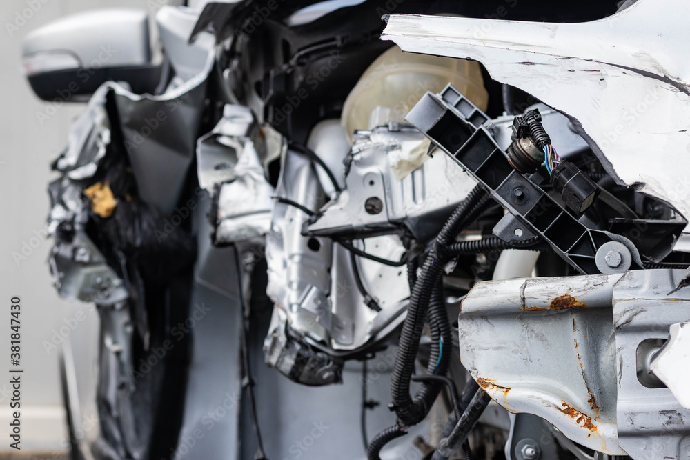 Close up shot of the remains of a wrecked vehicle after a serious car crash. Aftermath of drinking under influence, bent metal parts, smashed structure, ripped wires. Transport insurance concept. Close up shot of the remains of a wrecked vehicle after a serious car crash. Aftermath of drinking under influence, bent metal parts, smashed structure, ripped wires. Transport insurance concept.