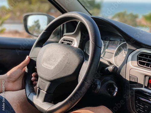 Man's hands driving a car while driving. Travel concept.