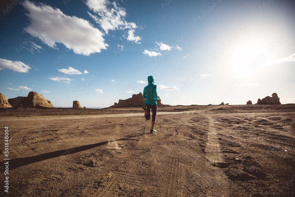 Fitness woman trail runner cross country running  on sand desert