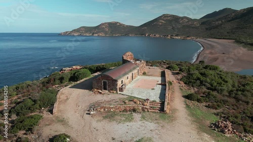 Aerial view of the 16th century Genoise tower overlooking Galéria beach and the Mediterranean sea in Corsica under a clear blue sky