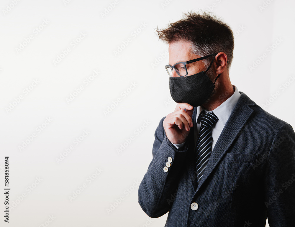 mature businessman with mask to avoid covid 19 or coronavirus. He is pensive and meditative. White background mature businessman with mask to avoid covid 19 or coronavirus. He is pensive and meditative. White background