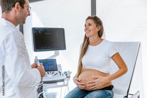 Pregnant patient talking with doctor after sonography photo