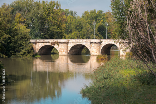 ashlar stone medieval bridge, puente mayor, crossing rio carrion, in autumn. Palencia, Spain.