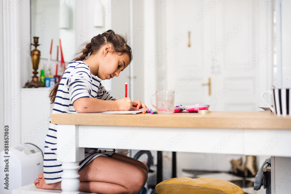 Cute smart primary school child girl learning writing doing homework sit at home table, adorable pretty little preschool kid studying alone making notes, children elementary education concept Cute smart primary school child girl learning writing doing homework sit at home table, adorable pretty little preschool kid studying alone making notes, children elementary education concept