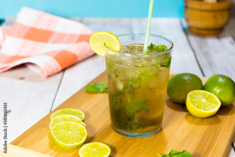 Cuban mojito made with rum, lime, brown sugar and soda on a wooden board. typical Cuban drink Cuban mojito made with rum, lime, brown sugar and soda on a wooden board. typical Cuban drink