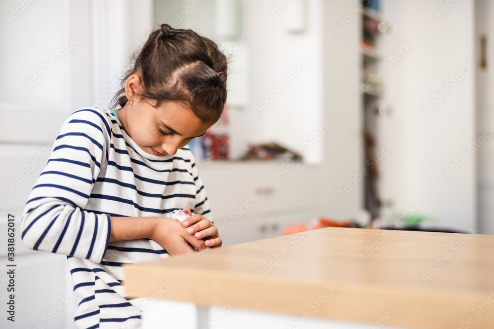Little girl holds white furry little mouse on white background. Funny fluffy pet. Beautiful curious spotted mouse. Little girl holds white furry little mouse on white background. Funny fluffy pet. Beautiful curious spotted mouse.