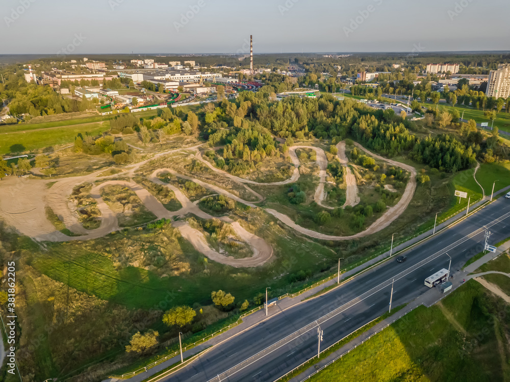 Top view from a drone of a motocross race track on the outskirts of the city, off-road on a Sunny day