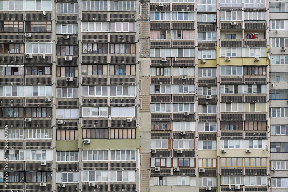 Texture of the facade of a multi-storey residential building with windows and balconies. Old Soviet design