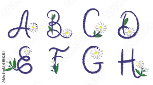 Latin alphabet letters stylized as embroidery, decorated with daisies.