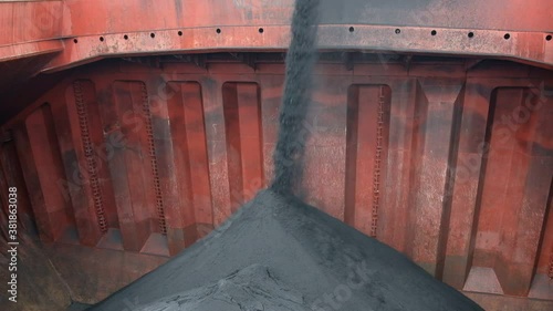 View of loading of iron ore concentrate in bulk into cargo hold of bulk carrier