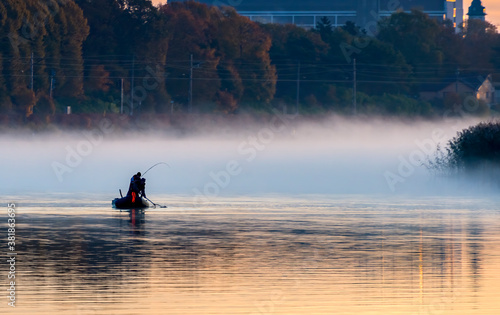 Sport fishing on a big river during autumn and with mist above water, Baltic Region, Europe