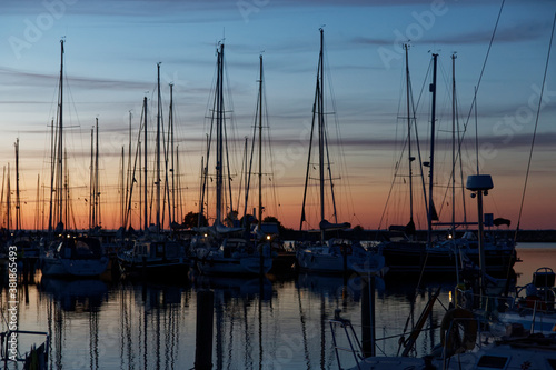 Hafenszene mit Segelbooten bei Sonnenuntergang, Licht am Horizont von Orange bis hellblau