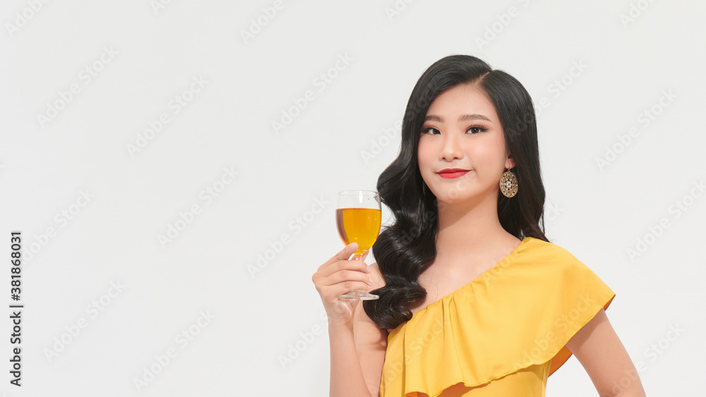 Young happy woman in yellow dress looking away and smiling with champagne isolated Young happy woman in yellow dress looking away and smiling with champagne isolated