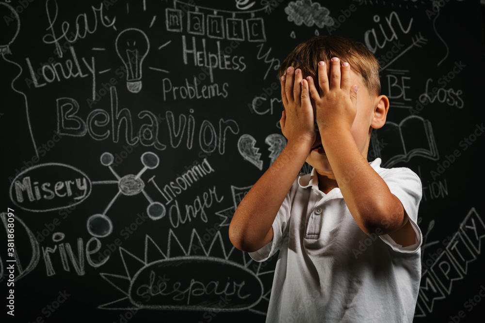 child whose depression is on a black background with his hands closed child whose depression is on a black background with his hands closed