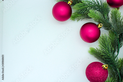 Christmas white background flat lay with pink ornament balls and decorations and the Christmas tree