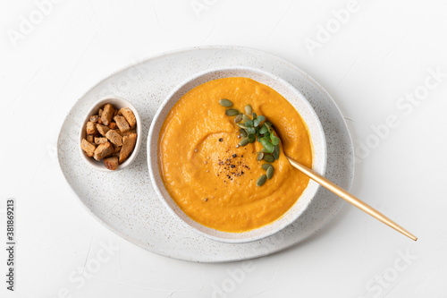 Fall pumpkin soup with crackers on white background. Top view. Space for text.