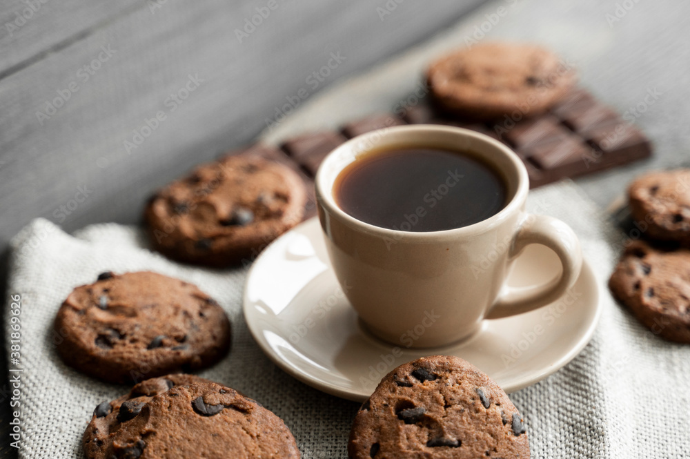 Coffee cup with cookies and chocolate on wooden table background. Mug of black coffee with chocolate cookies. Fresh coffee beans. - obrazy, fototapety, plakaty 