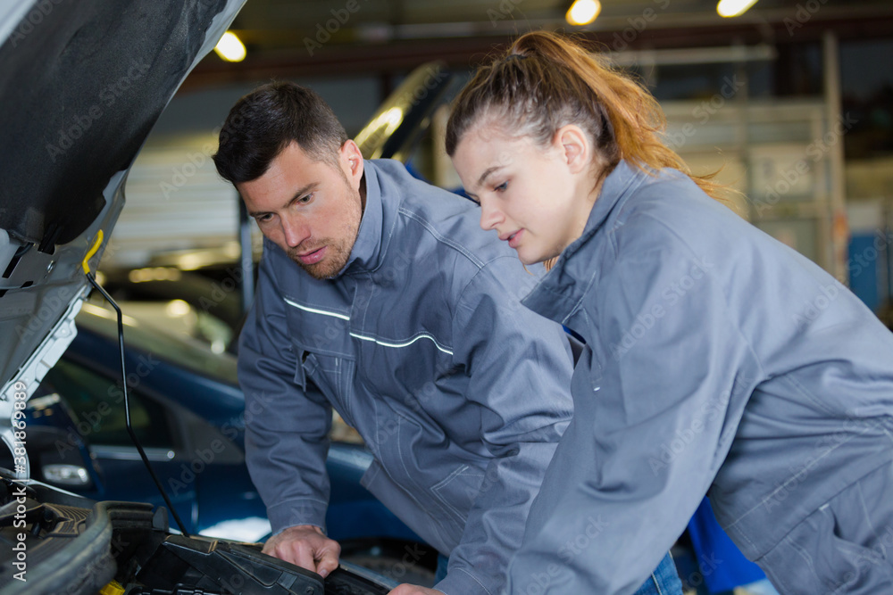 mechanic man and woman examine a car mechanic man and woman examine a car