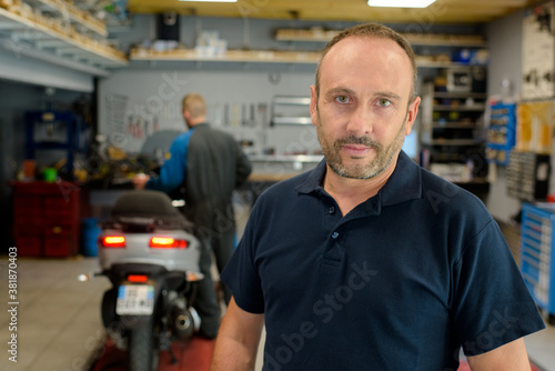 man in the motorbike mechanic shop posing
