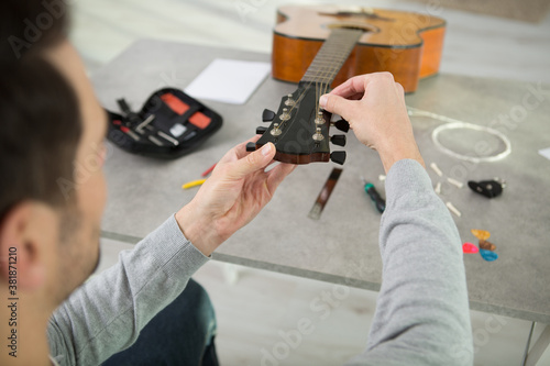 Fotografie man repairing acoustic guitar in his workshop