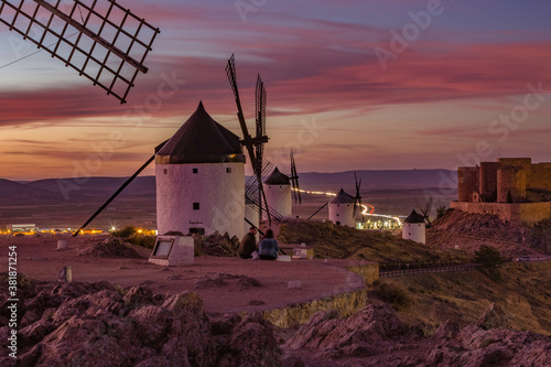 Beautiful white spanish windmill on the hill at fairy blue pink gold sunset near the castle in Consuegra, Toledo province, Spain