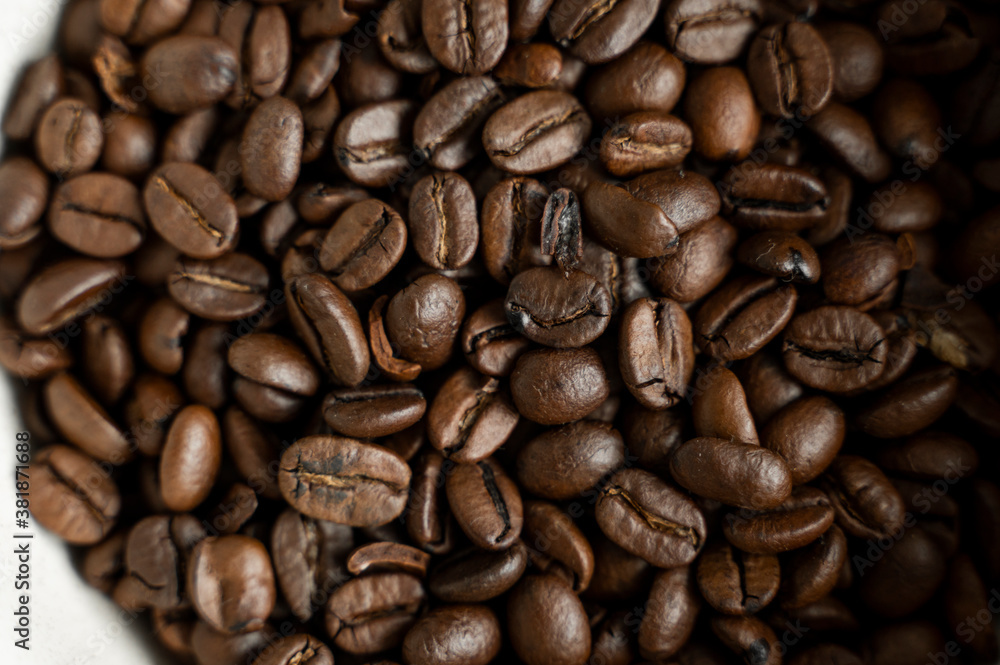 Bowl filled of fresh arabica or robusta coffee beans on a wooden table. Bowl filled of fresh arabica or robusta coffee beans on a wooden table.