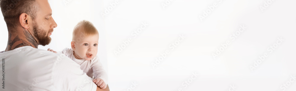 horizontal concept of young tattooed man holding infant child on hands horizontal concept of young tattooed man holding infant child on hands
