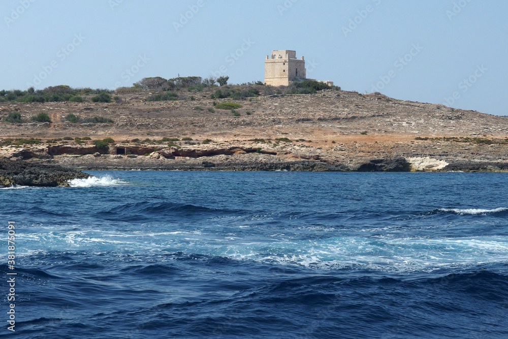 Comino island rocky coast landscape with old fortress and blue sea, Malta