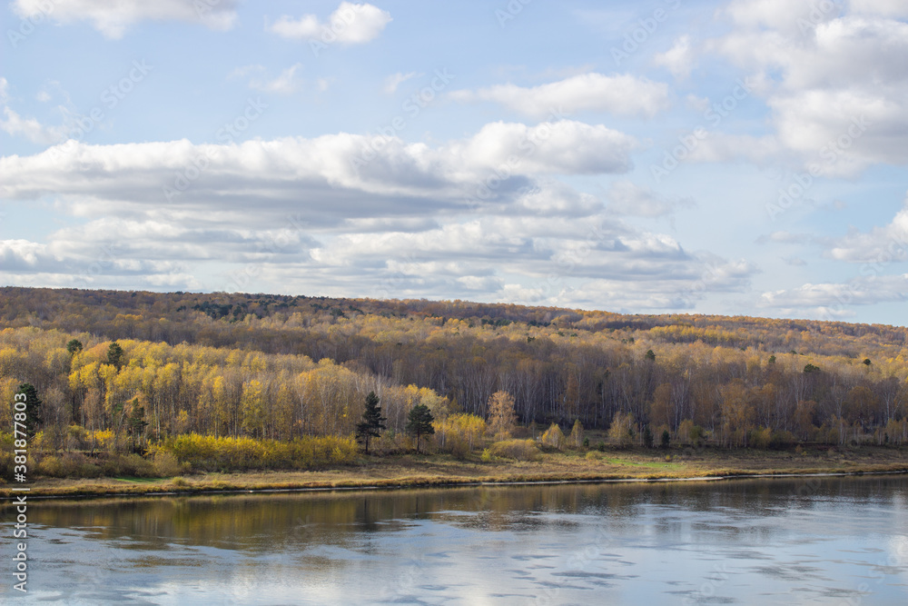 Beautiful, wide river autumn among the woods.