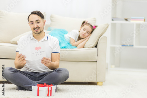 Photo of handsome young man at home with his little cute girl.