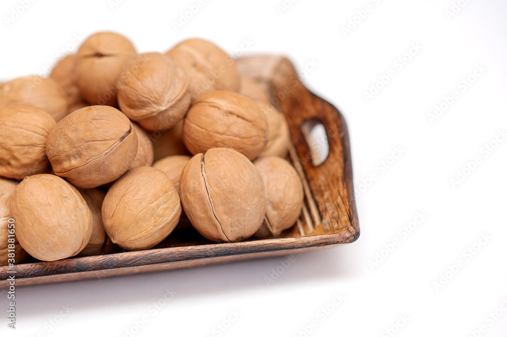 walnuts in a wooden bowl on a white background. walnuts in a wooden bowl on a white background.
