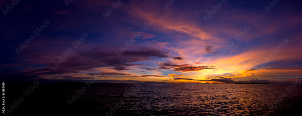 Panorama Beautiful colorful sunset at the sea with dramatic clouds and sun shining.