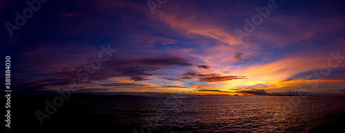 Panorama Beautiful colorful sunset at the sea with dramatic clouds and sun shining. © noon@photo