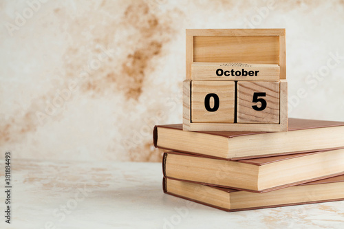 Wooden calendar October 5 on a stack of books. World teacher's day