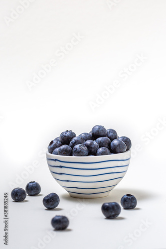 Close-up of fresh blueberries on a white and blue bowl on white background