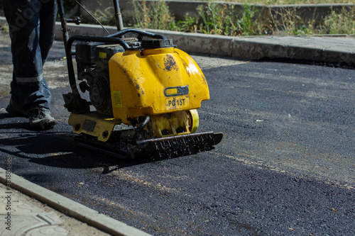 Vibratory plate for asphalt. Pothole repair process. Asphalt compaction machine. New asphalt